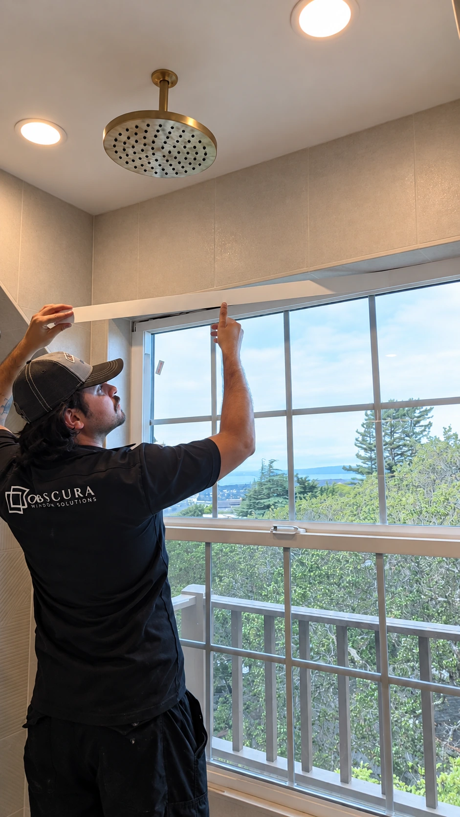 An installer preparing the upper edge of a bathroom window